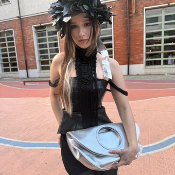 Model at Polimoda Florence carrying silver LUCY clutch, black structured outfit with leaf headpiece