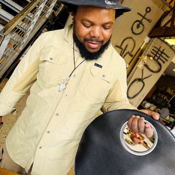 Andile Dyalvane holding a black LUCY bag at his Cape Town studio